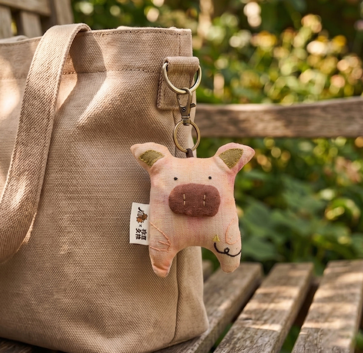 Pingente de bolsa em linho com porquinho rosa