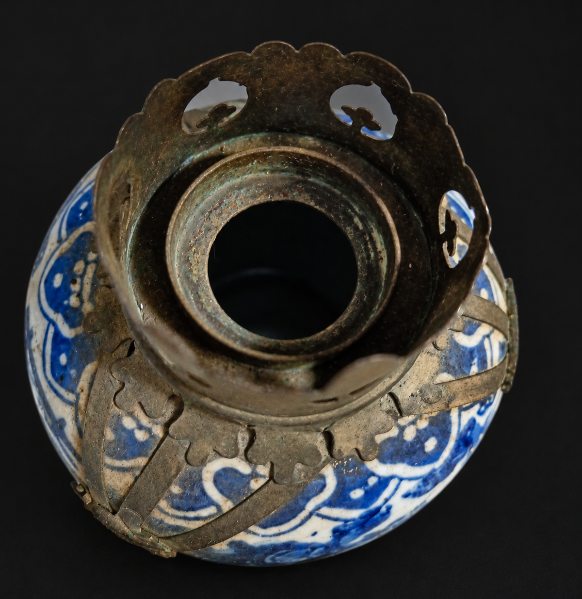 Close-up of pierced metal crown and candle opening