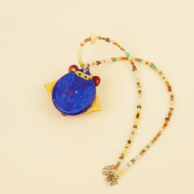 Red Spirit Pendant - Blue Ground – side view showing shape and hand-stitched details