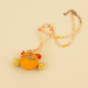 Golden Crown Spirit Pendant - Red Doll Face – close-up of linen, patchwork, and textile texture
